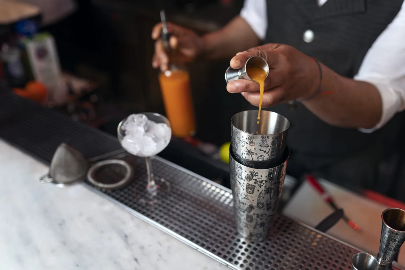 Bartender pouring an orange cocktail