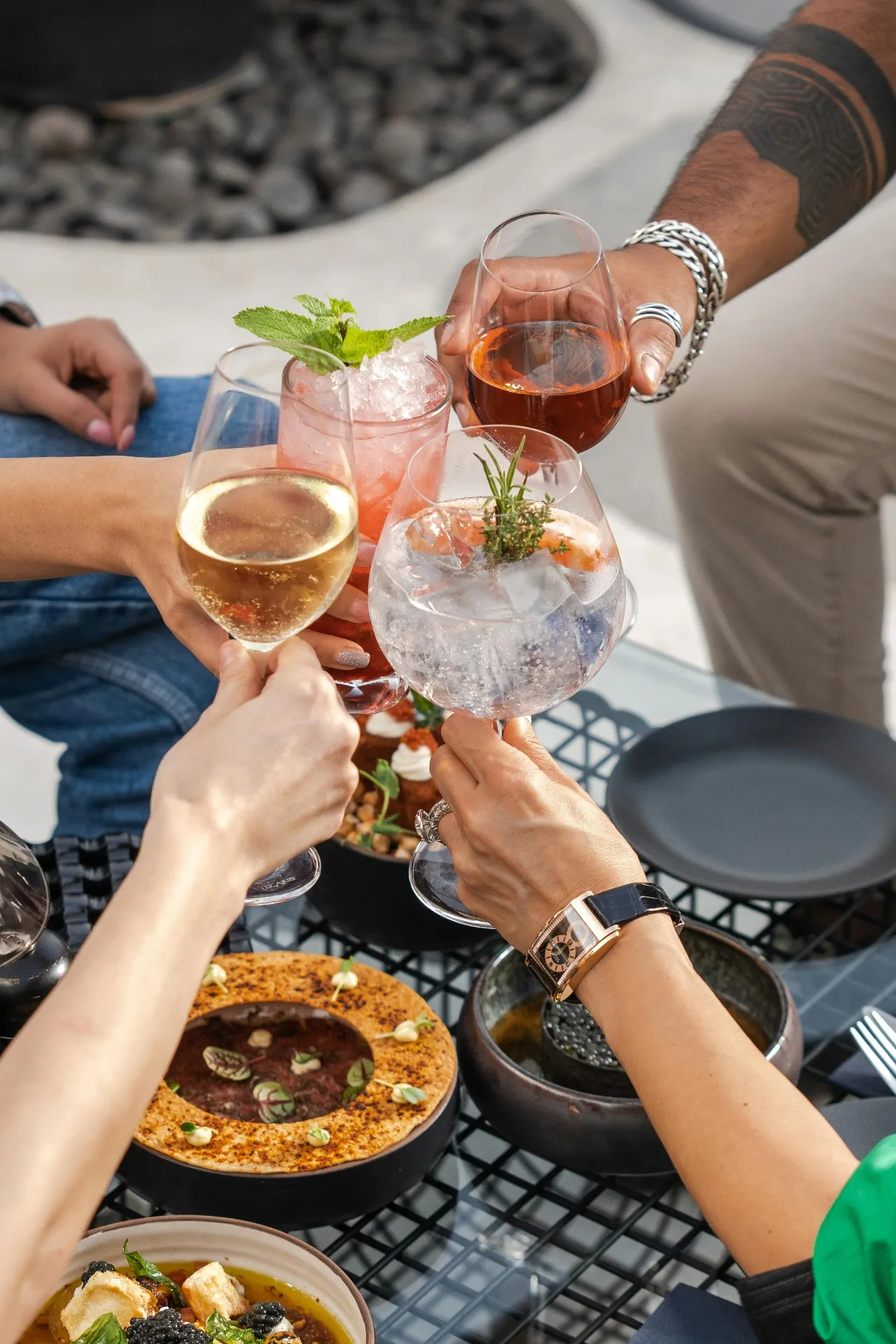 Friends cheering with cocktails over a curated table